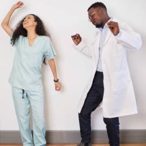 Team of three medical professionals dance on a break, doctor having fun. High quality photo